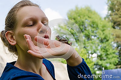 Cinderella kissing little frog on palm Stock Photo