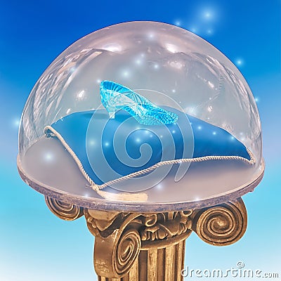 Cinderella`s crystal shoe on a blue pillow close-up. Stock Photo