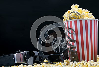cinema snack bar on black background, bucket of nachos with video tape and retro camera Stock Photo