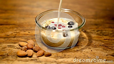 Cinemagraph of glass bowl with cereal and fresh milk. On wooden table Cinemagraph of glass bowl with cereal and fresh milk. On wooden table