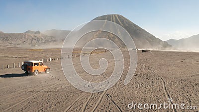 Cinematic shot aerial view of tour jeep cruise at beautiful Mount Bromo volcano with desert in East Java Editorial Stock Photo