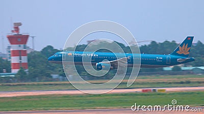 Cinematic shot of a large blue passenger aircraft landing in Hanoi on sunny day. Editorial Stock Photo