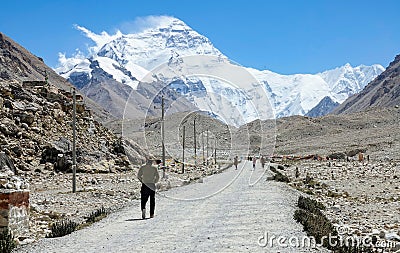 Cinematic shot of travelers hiking towards breathtaking windswept Mount Everest. Editorial Stock Photo