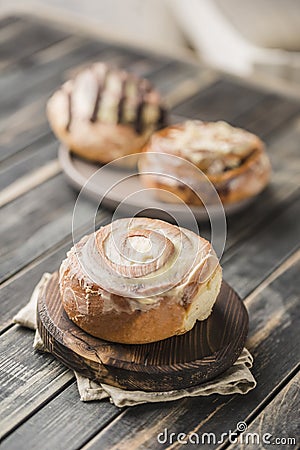 Cinnabon buns on a wooden Board with a napkin on a dark background Stock Photo