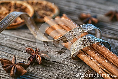 Cinnamon sticks with ribbon, spices and walnuts on wooden table, wishing merry christmas Stock Photo