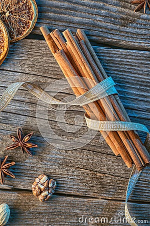 Cinnamon sticks with ribbon, spices and walnuts on wooden table, wishing merry christmas Stock Photo