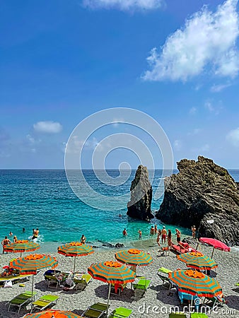 Cinque Terre beach with striped orange beach umbrellas Editorial Stock Photo
