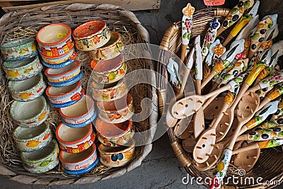 Cinque Terre, Italy - ceramic bowls and wooden spoons on baskets. Local souvenirs sold in Riomaggiore. Stock Photo