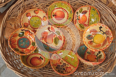 Cinque Terre, Italy - colorful ceramic bowls displayed on a basket. Local souvenirs sold in Riomaggiore. Stock Photo