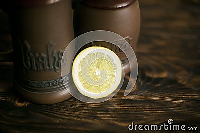 A circle of lemon on a brown background with beer mugs Stock Photo