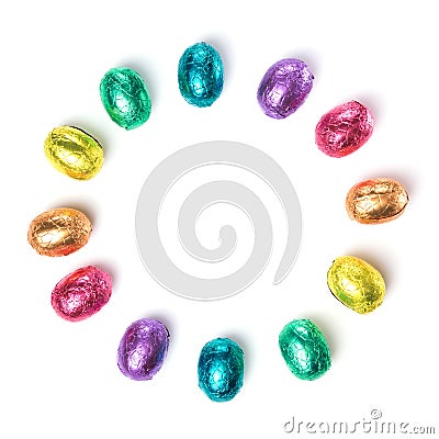 Circle made of chocolate easter eggs wrapped in multi colored foil isolated on white background Stock Photo