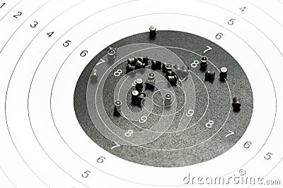 Circle shooting target and lots of metal pellets laying on top, object closeup, detail, nobody. Airgun sports, accessories. Pellet Stock Photo