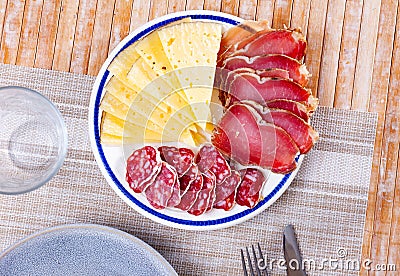 Circles of sausage butifarra, slices of prosciutto ham are complemented by triangular sliced cheese Stock Photo