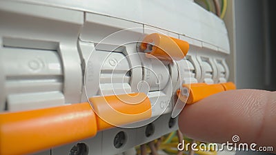 Circuit breaker switching. Close up of finger switching off high voltage electric power line. Power supply switches in Stock Photo