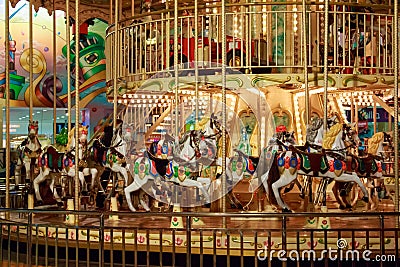 Circular children`s carousel with colorful horses and cars Editorial Stock Photo