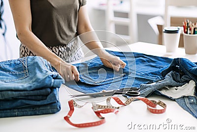 Circular economy. Sustainable fashion. Reuse, repair, upcycle. Denim upcycling ideas, repair and using old jeans. Woman Stock Photo