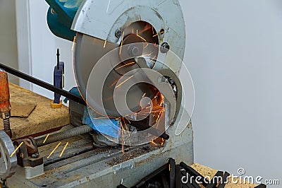 Circular electro saw cutting iron steel railings fence by with sparks Stock Photo