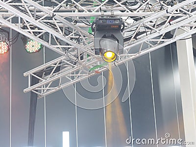 Circular spotlight mounted on a metal frame truss Shining yellow in concert Stock Photo
