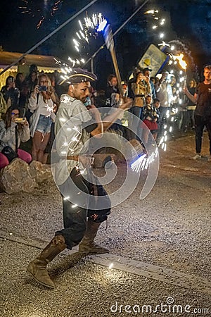 circus arts group juggling fire performing at the black pig theme park distillery in Santiago do Cacém. Editorial Stock Photo