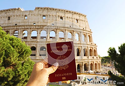 Citizenship concept: hand hold Italian passport in front of Colosseum in Rome Stock Photo