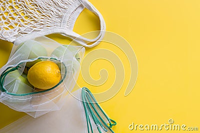 Citrics in reusable eco-friendly mesh bags with on yellow background. Zero waste concept. Ecological shopping. Stop pollution Stock Photo