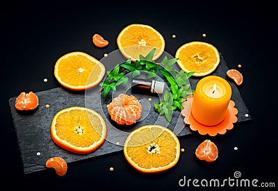 Citrus aroma oil concept â€“ glass bottle with essence, tangerine and orange slices Stock Photo