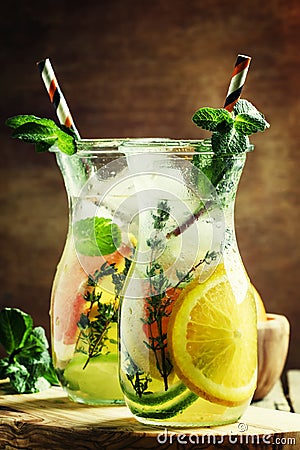 Citrus cool lemonade in glass jugs, vintage wooden background, s Stock Photo