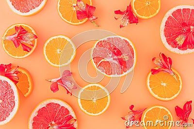 Citrus fruits and red flowers in an orange background Stock Photo