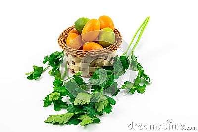 Citrus fruits in a basket exotic kumquats and limequats on a white isolated background and with greens Stock Photo