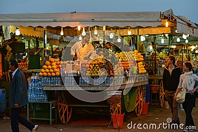 Citrus fruits juice stall with vendor in Djamaa El Fna square in Marrakesh, Morocco, Africa night scene Editorial Stock Photo