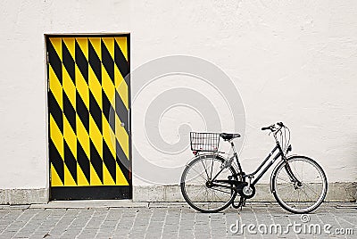 City bike againtst a big wall with door Stock Photo