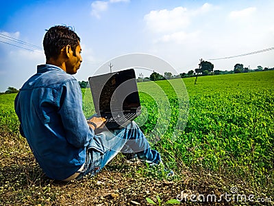 A city boy holded laptop at green field area in India January 2020 Editorial Stock Photo