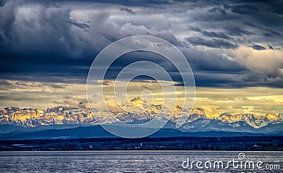 The city Constance on the Lake Constace, Bodensee. The view of sunset at the snowy mountains Alps. Thelake lies in Germany, Stock Photo