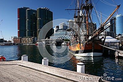 Moored historic sailing ship with iconic cityscape of modern skyscrapers on harbor waterfront, Darling Harbour, Sydney, Australia Editorial Stock Photo