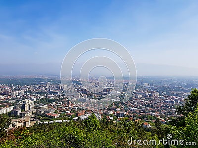 City landscape with trees in foreground on a sunny day Stock Photo