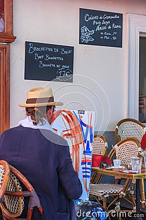 City landscape - view of the Parisian cafe in Montmartre with the artist who paints a portrait Editorial Stock Photo