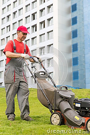 City landscaper worker cutting grass Stock Photo