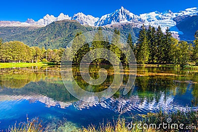 The lake reflected the snow-capped Alps and evergreen spruce Stock Photo