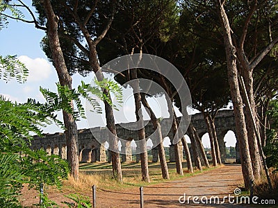 Ancient aqueduct in a park to Rome in Italy. Stock Photo