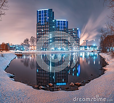 City pond in winter with modern residential buildings on the shore and reflection in the water. Yekaterinburg, Russia Stock Photo