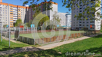 In the city quarter, among residential buildings, next to grass lawns and trees, there are sports grounds for basketball and footb Stock Photo