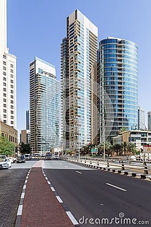 City scape with modern high-rise buildings, road and blue sky in background at Dubai Editorial Stock Photo