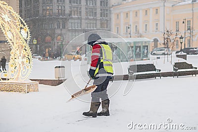 city service guy clean snow from streets with shovel b Editorial Stock Photo