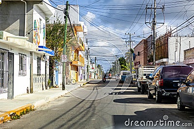 City street with multiple cars parked along the side in Cozumel, Maxico Editorial Stock Photo