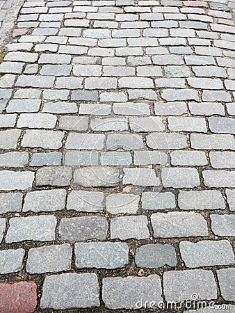 City street paved with colorful cobblestones pavement with ground between the plates Stock Photo