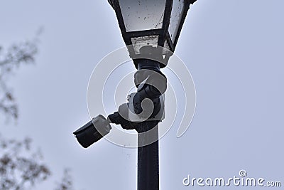 A city surveillance camera mounted on a historic lighthouse on a gloomy autumn day. Autumn Editorial Stock Photo