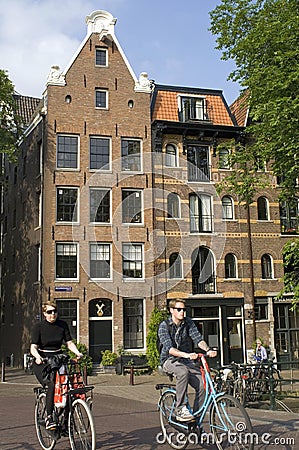 City view with canal houses, bikers, in Amsterdam Editorial Stock Photo