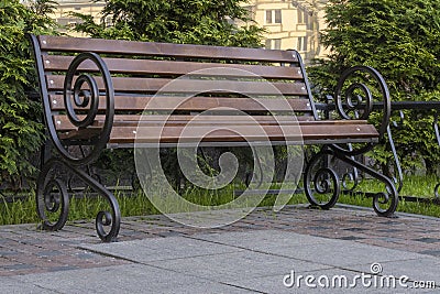 City wooden bench with swirl shape legs on sunny summer day. Copy space Stock Photo