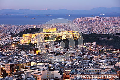 Cityscape of Athens with illuminated Acropolis hill, Pathenon and sea at night, Greece Stock Photo