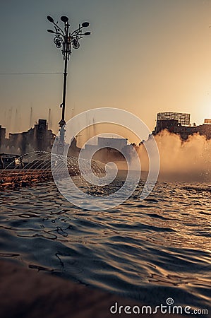 Cityscape featuring a water fountain against the backdrop of buildings in Bucuresti, Romania Editorial Stock Photo